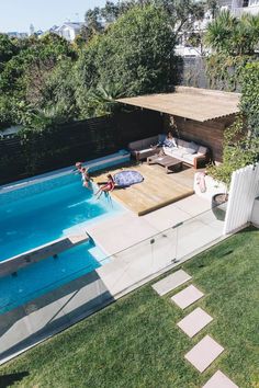 two people sitting on the edge of a swimming pool