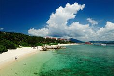 people are walking on the beach near the water