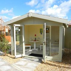 a small garden shed with sliding glass doors on the front door and patio area in the back