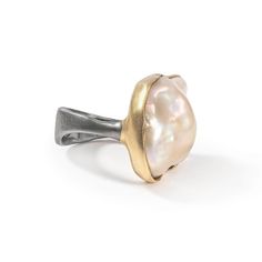 This ring is a testament to craftsmanship and individuality, embodying a blend of natural beauty and bold self-expression. It features a solid band to offer a continuous circle of textured silver in the German Kabirski style. Atop this unique band sits a natural freshwater Baroque Pearl, balanced by a small, round-cut Rhodolite Garnet, creating a harmonious contrast. The silver is plated with Ruthenium and 18K Gold, achieving a finish that not only enhances durability and tarnish resistance but Unique Bands, August Birthstone Jewelry, July Birthstone Jewelry, Fine Art Jewelry, Jewelry Metal, Rhodolite Garnet, Jewelry Ring Box, Pearl Jewellery Earrings, Men's Jewelry Rings