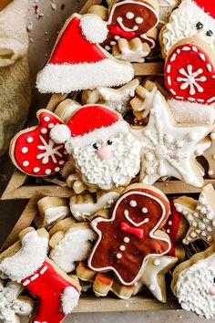 christmas cookies decorated like santa claus and snowflakes on a wooden board with white icing