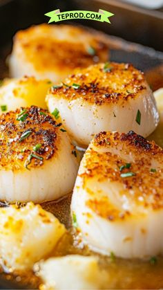 seared scallops are being cooked in a skillet