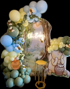 an arch with balloons and winnie the pooh decorations