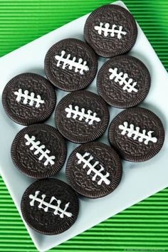 chocolate football cookies on a plate with white crisscrossed lines around the edges