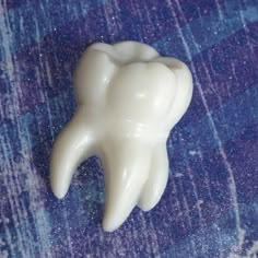 a tooth shaped object sitting on top of a blue carpet