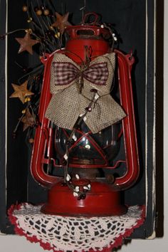 an old fashioned red lantern with a bow on it