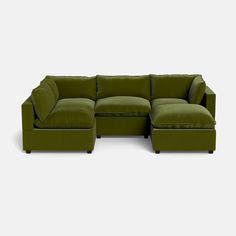 a green sectional couch with pillows on the back and footrests, in front of a white background