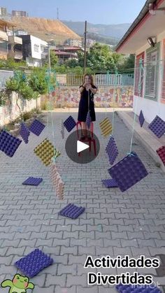 a woman standing in front of a building with lots of purple and yellow squares on the ground