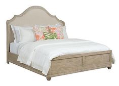 a bed with white linens and pillows on it's headboard, in front of a white background