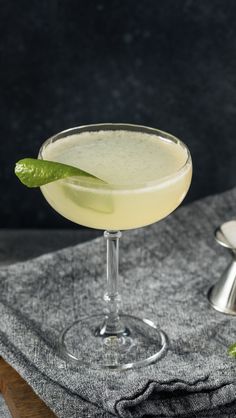 a glass filled with a drink sitting on top of a table