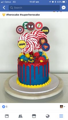 the cake is decorated with candy and decorations on it's top tier, as well as an image of spider - man