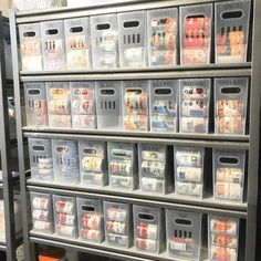 several bins are stacked on top of each other in front of a metal shelving unit