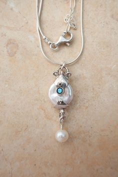 From Porans collection  White coin pearl sterling silver pendant  Pendant earrings set matching earrings: https://www.etsy.com/il-en/listing/1754492550/sterling-silver-pearl-drop-earrings?click_key=15fea1ef9adaca16c3ccad0c72de8ea273633e4e%3A1754492550&click_sum=71d0ca22&ref=shop_home_active_1&frs=1&sts=1 Pendant Dimensions: Length: 1.18 inches Width: 0.39 inches The length of the chain is usually 18" - 22",  yet can be made at any size you wish, if you are interested in a specific length, Please Silver Jewelry With Oval Pendant And Pearl Charm, Sterling Silver Drop Necklaces With Pearl Charm, Silver Jewelry With Pearl Charm In Oval Pendant, Sterling Silver Dangle Pearl Necklace Gift, Sterling Silver Necklace With Pearl Charm Dangle, Dangle Sterling Silver Pearl Necklace For Gift, Silver Pendant Pearl Necklace With Adjustable Chain, Bohemian Silver Pendant Pearl Necklace, Silver Pearl Necklace