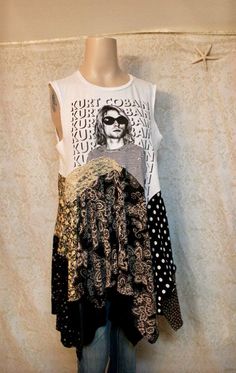 a mannequin wearing a white shirt with black and gold designs on it