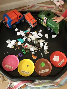 a black tray filled with lots of different types of toy cars and toys on top of it