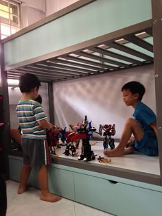 two boys playing with legos in a bunk bed