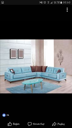 a blue sectional couch sitting on top of a wooden floor next to a coffee table