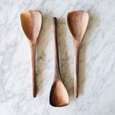 two wooden spoons sitting on top of a marble counter