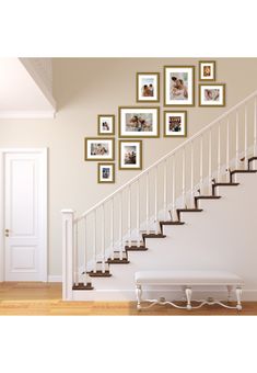 a stair case with pictures on the wall and a bench underneath it in front of a set of stairs