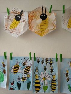 paper bags with bees hanging from them on clothes pins in front of a white wall