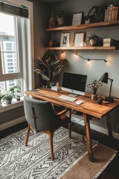 a desk with a computer on top of it in front of a window next to a potted plant