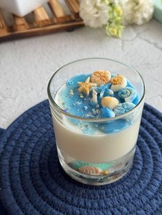 a glass filled with milk sitting on top of a blue mat