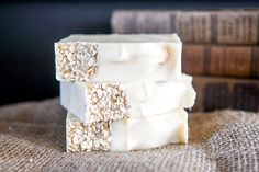 three bars of oatmeal soap stacked on top of each other next to some books