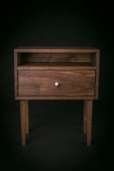 the side table is made out of wood and has two drawers on each side, one with