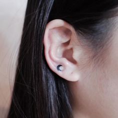 a woman's ear with two small black dots on it