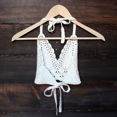 a white top hanging on a wooden hanger