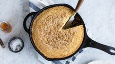 a skillet with a cake in it on top of a table next to other dishes