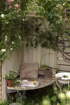 an outdoor table and bench with flowers on it