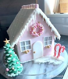 a pink gingerbread house decorated with candy canes