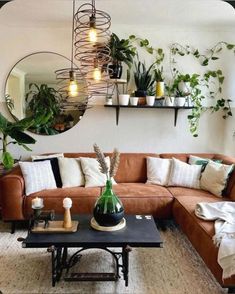 a living room filled with lots of plants next to a wall mounted planter and mirror