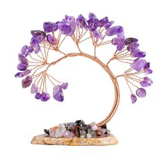 a purple crystal tree sculpture with rocks on it's base and the branches are filled with amethyst crystals