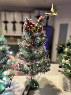 three small christmas trees sitting on top of a table