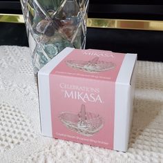 a pink box sitting on top of a table next to a vase