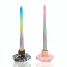 two colorful candles sitting next to each other