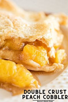 a close up of a piece of food on a plate with words above it that read double crust peach cobbler