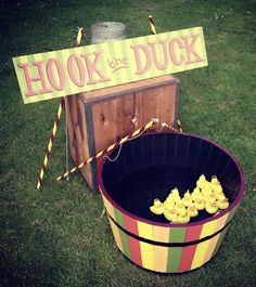 a bucket filled with yellow candy sitting on top of a grass covered field next to a sign that says hook and duck