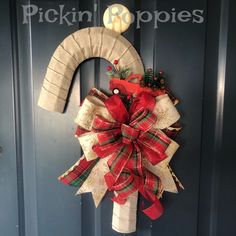 a christmas wreath on the front door of a house with an oar hanging from it's side