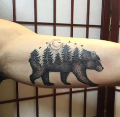 a man with a bear tattoo on his arm