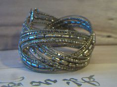 Beaded cuff bracelet. It measures approx. 1-1/2 inch thick and is flexible and should fit most size wrists. Made with small gold seed beads. It has a woven design. Add it to your jewelry wardrobe. Pre owned in great condition. All sales are final and as is. Thank you for looking. You may also love this: https://www.etsy.com/listing/510068528/brown-bronze-beaded-cuff-bracelet-woven?ref=shop_home_active_3 Silver Metal Beaded Bracelets With Gold Beads, Silver Metal Beaded Bracelet With Gold Beads, Silver Beaded Bracelet With Gold Beads, Silver Beaded Metal Cuff Bracelet, Silver Beaded Bangle Bracelets With Gold Beads, Silver Beaded Cuff Bracelet, Silver Beaded Bangle Cuff Bracelet, Jewelry Wardrobe, Beaded Cuff Bracelet