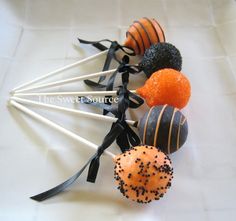 there are many different types of candies on the stick with black and orange sprinkles