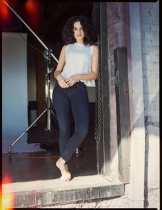 a woman is standing in front of a camera and posing for the camera with her hands on her hips