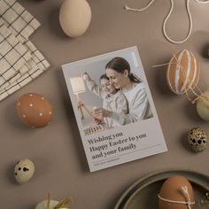 an easter card is laying on a plate next to some eggs and other items that are scattered around it