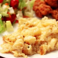 a white plate topped with food next to a salad