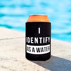 an orange and black can cooler sitting next to a swimming pool with the words identity as a water on it