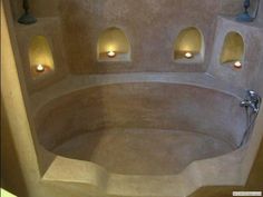 a bath room with a large tub and lights on the wall next to each other