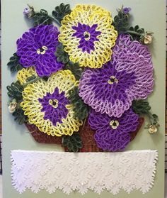 crocheted flowers are displayed on a card